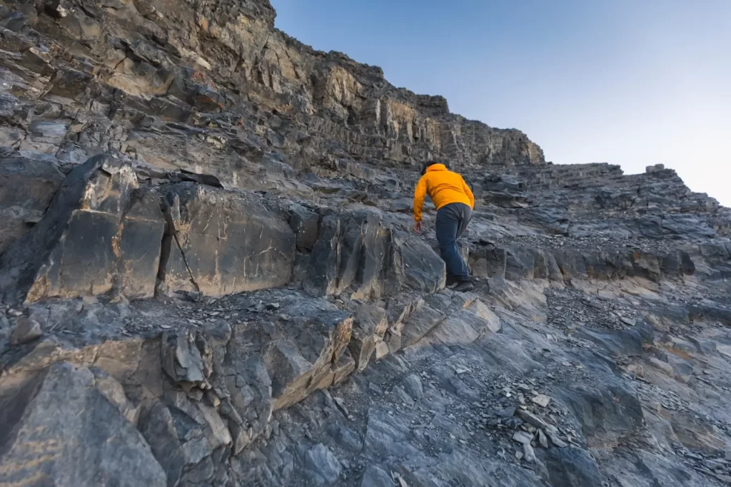 Scrambling up rocky ledges on the East End of Rundle hike