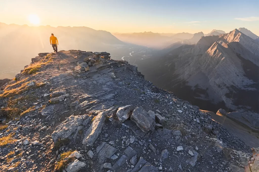 A hiker standing on the summit of EEOR in Canmore