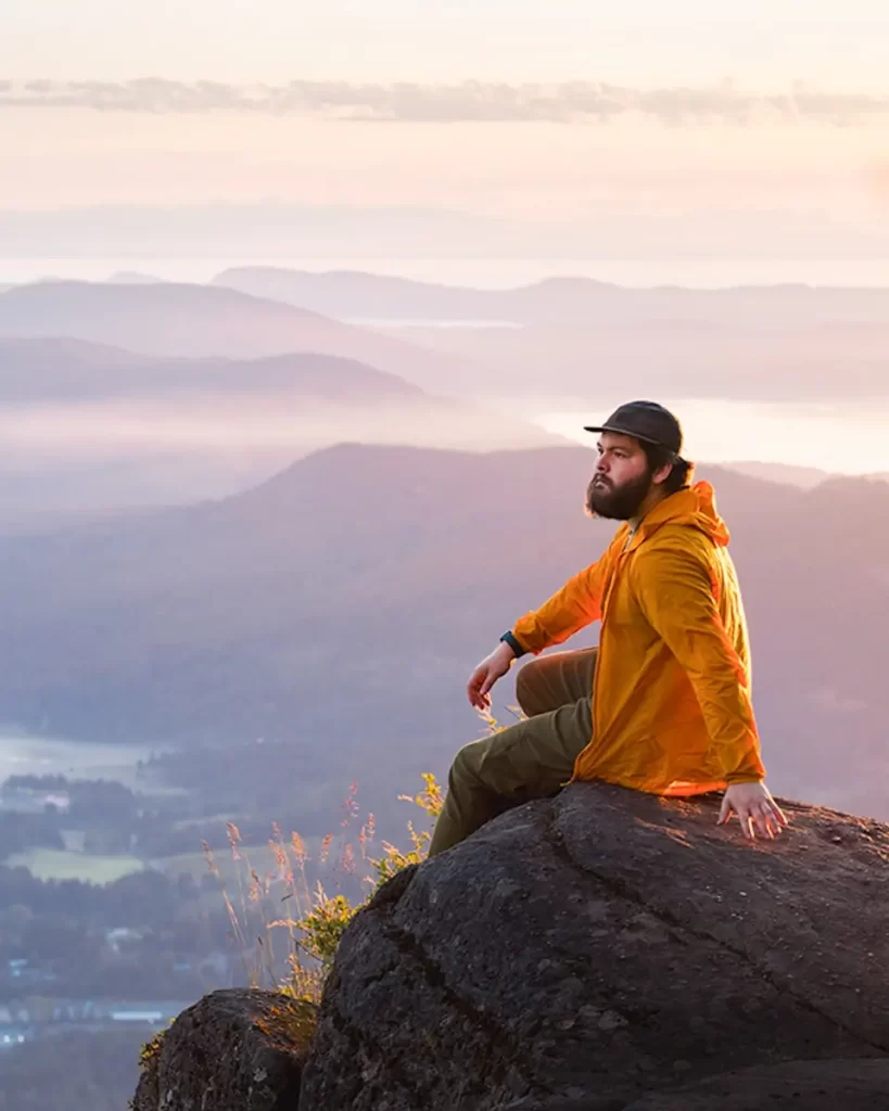 A portrait of J Quincy Harvey on a mountaintop