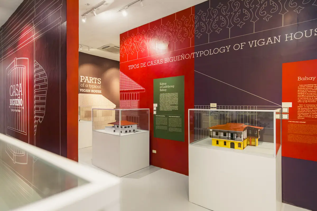 A museum exhibit displays architectural models of Vigan houses in glass cases, with informational panels on the walls—making it one of the best places in Vigan for learning about the typology and features of traditional homes.