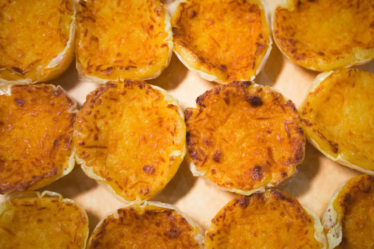 A close-up view of several baked cheese tarts arranged in rows on a light-colored surface, their golden brown tops slightly crispy—a delightful treat often found among the best places in Vigan for food lovers.