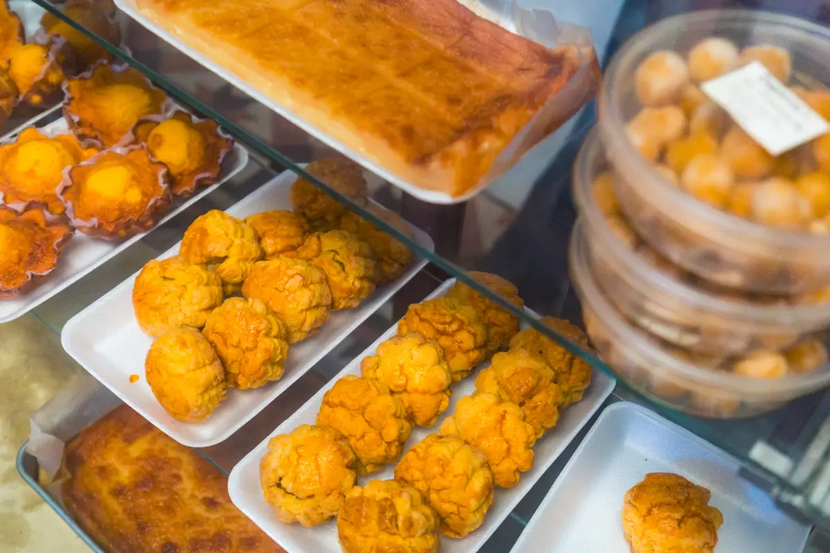 A display case featuring trays of assorted baked goods, including round, golden-brown pastries and rectangular treats—perfect for those exploring the best places in Vigan or searching for local flavors in any Vigan travel guide.